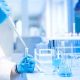 Test tubes in clinic, pharmacy and medical research laboratory with male scientist using pipette